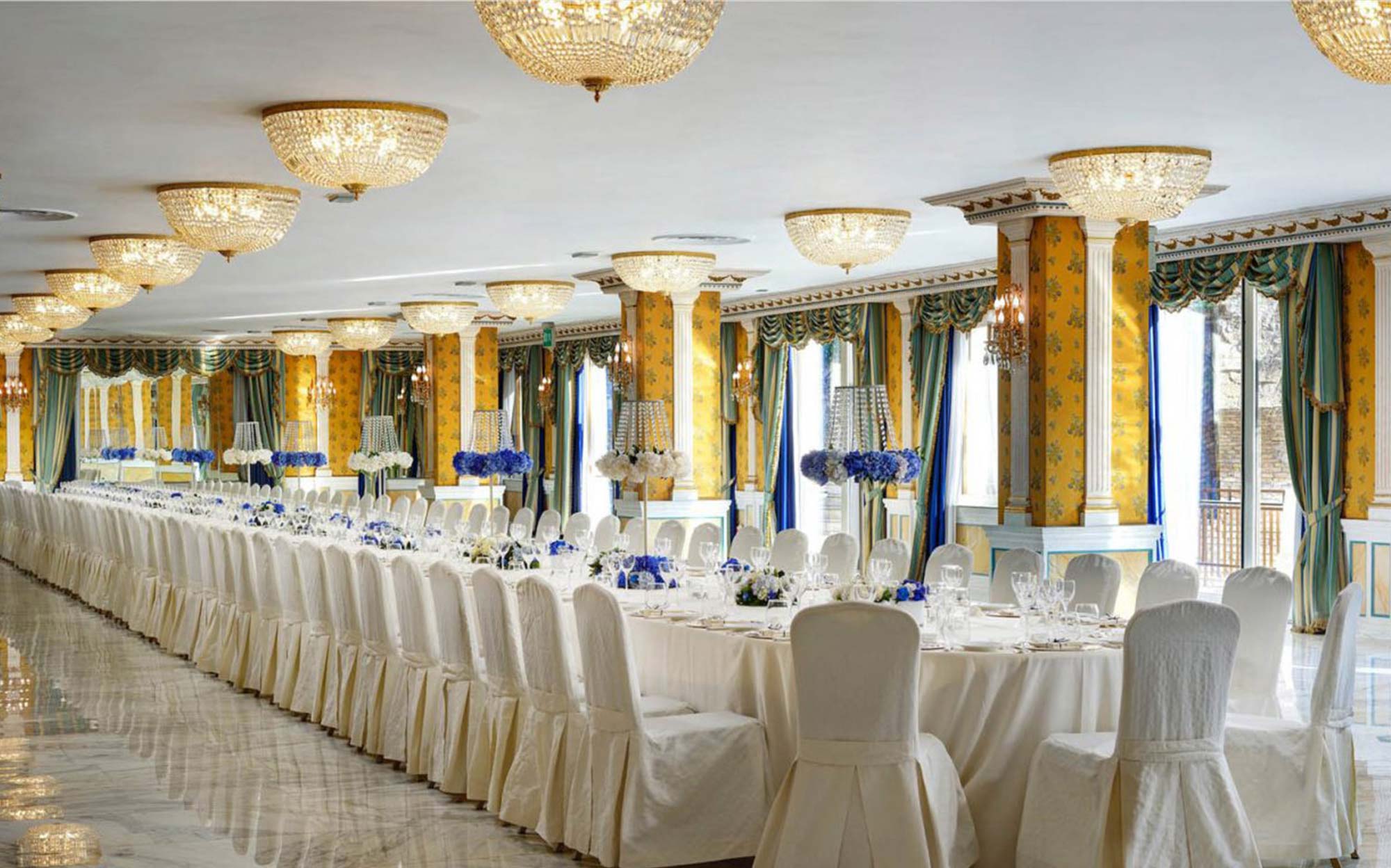 G. Moscatelli Crystal Ceiling Chandeliers in Luxury Interior | 101domus Luxury classic interior with G. Moscatelli crystal ceiling chandeliers illuminating an elegant banquet hall, refined Italian lighting design for prestigious interiors.