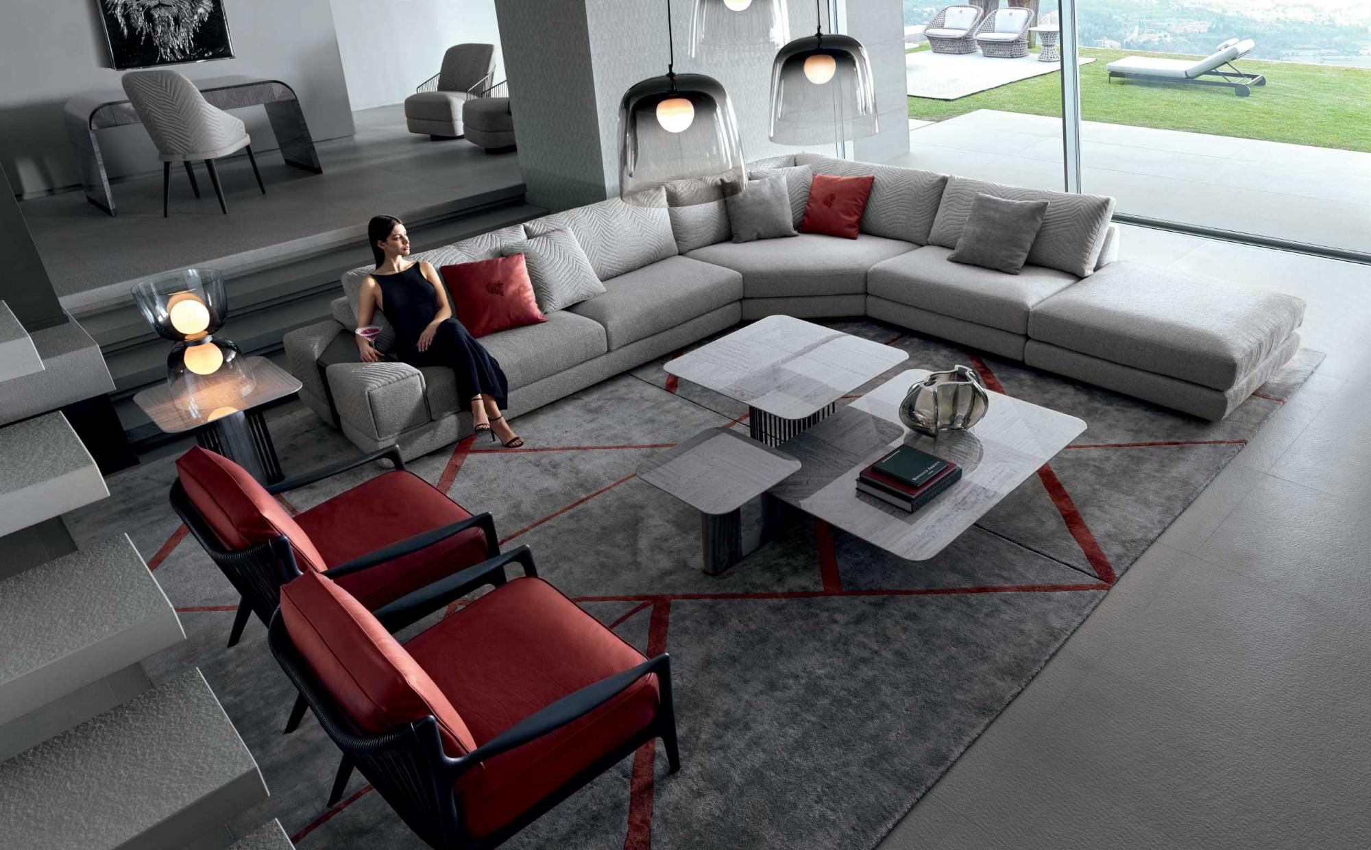 Living room with modular sofa and modern blown-glass lighting | 101DOMUS Modern living room with grey sectional sofa, sculptural coffee tables and glass pendant lights