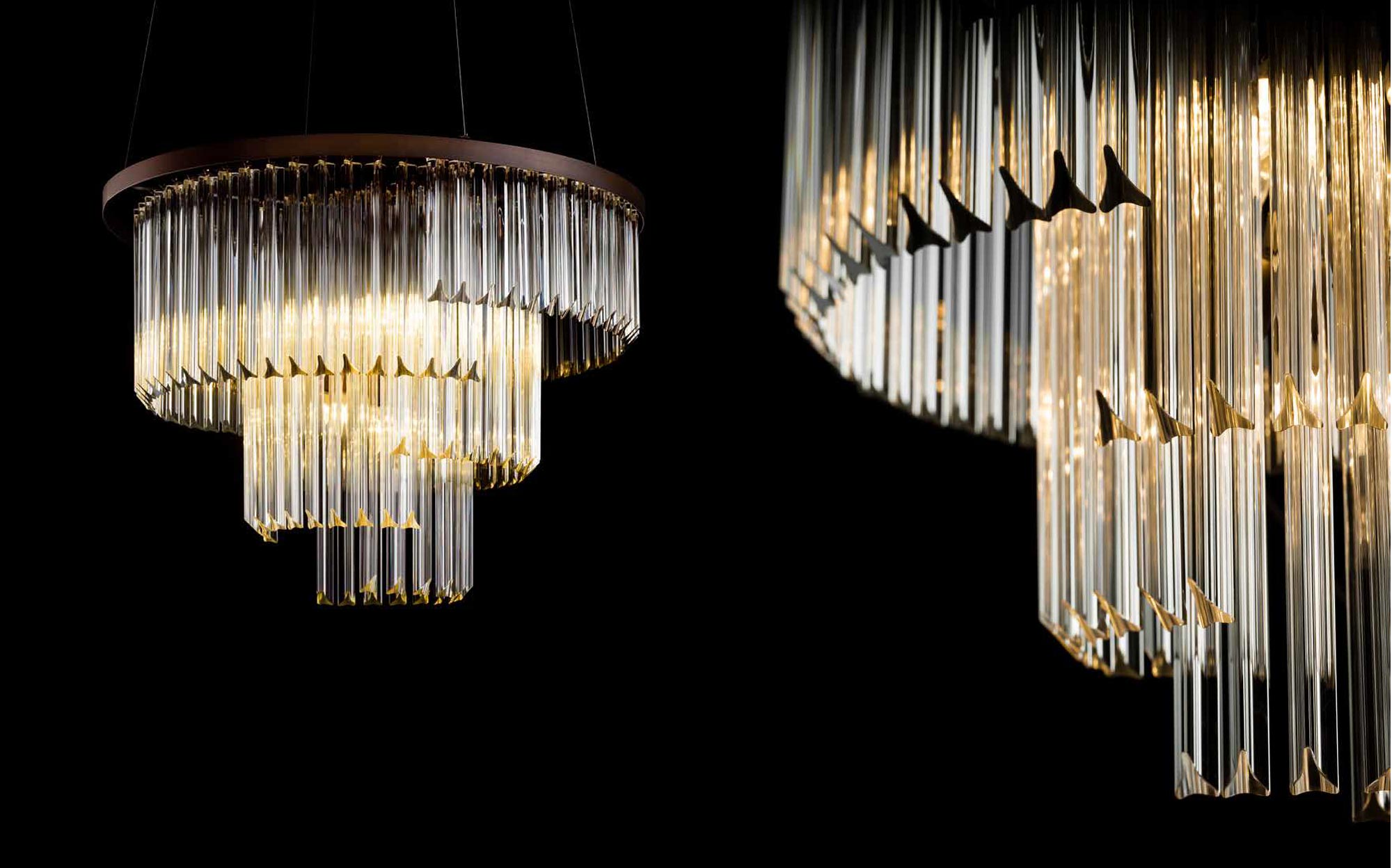 Contemporary chandelier by Il Paralume Marina featuring a circular metal frame and tubular glass diffusers with gold accents, elegant designer lighting for luxury interiors.