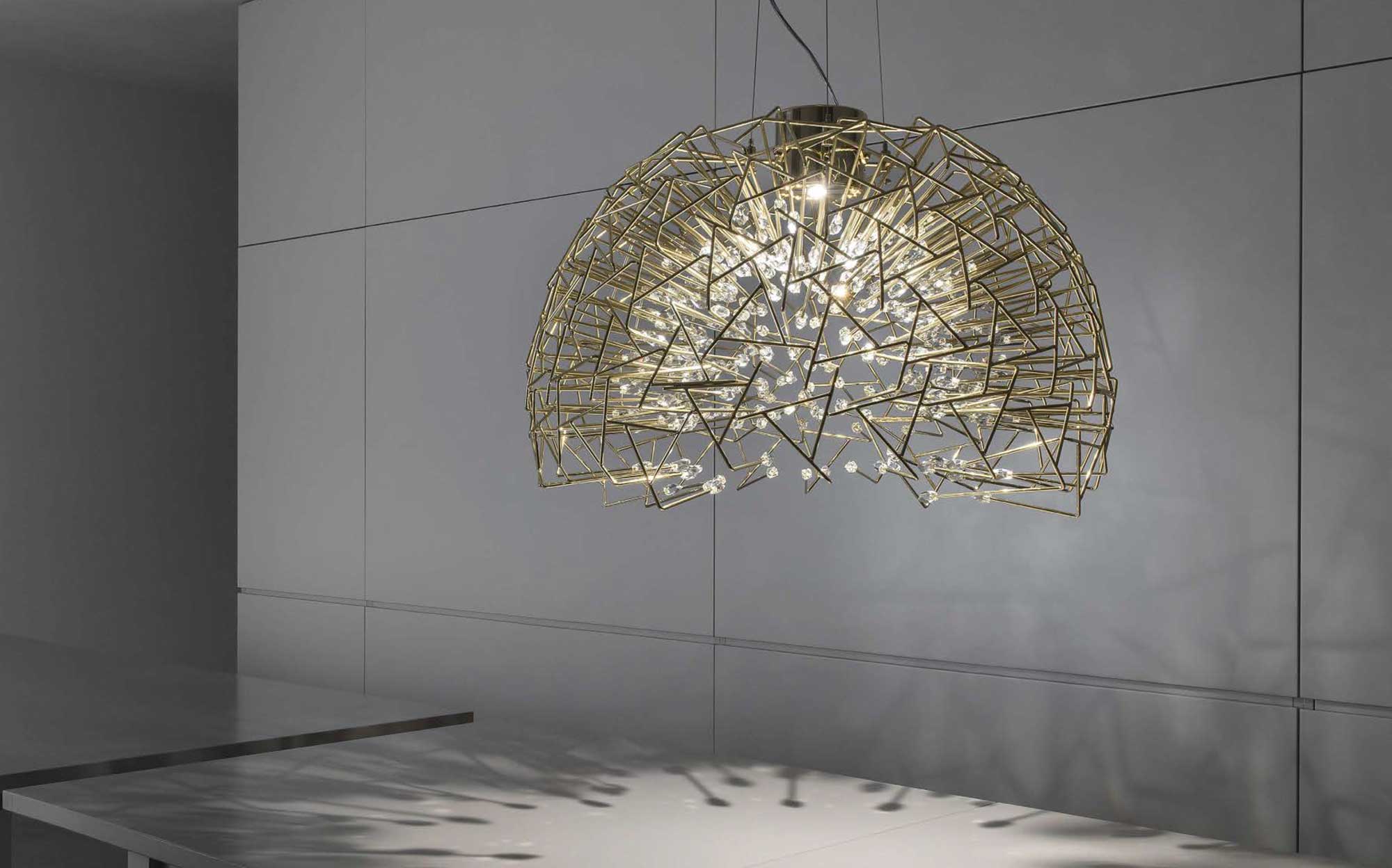 Terzani geometric brass and crystal chandelier: striking design for contemporary spaces | 101DOMUS Terzani brass chandelier with geometric structure and crystals suspended against a modern wall