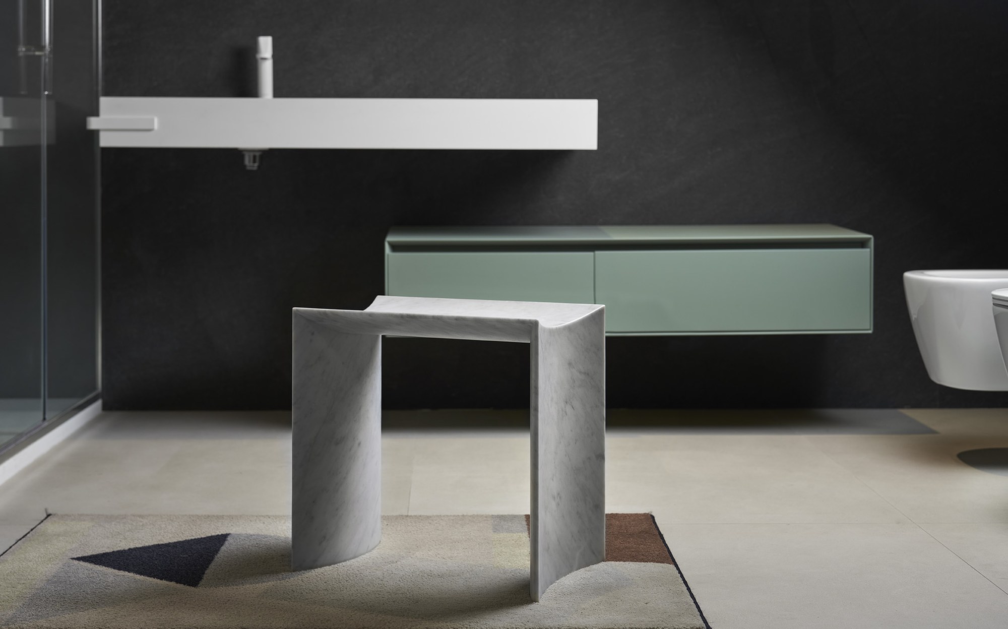 Bufalini marble washbasin and folded marble stool in a luxury bathroom by Paolo Ulian