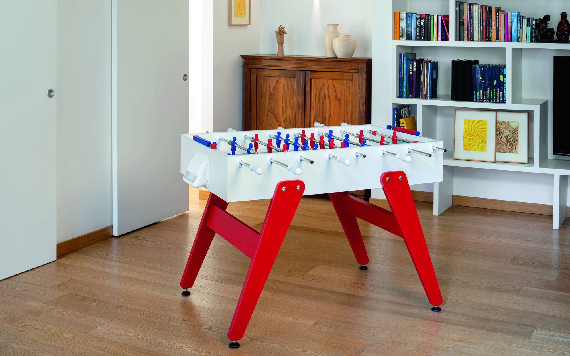 FAS Pendezza Cross Indoor designer foosball table with red legs in a modern home