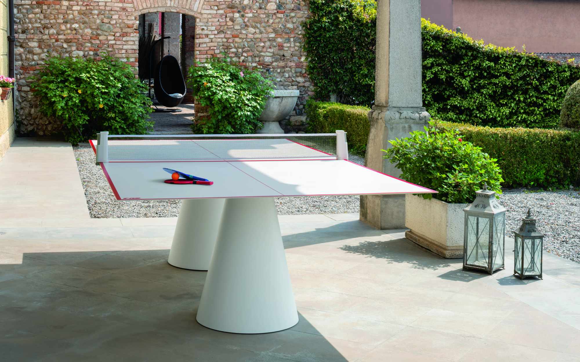FAS Pendezza Dada Outdoor ping pong table with white cone bases in an Italian garden