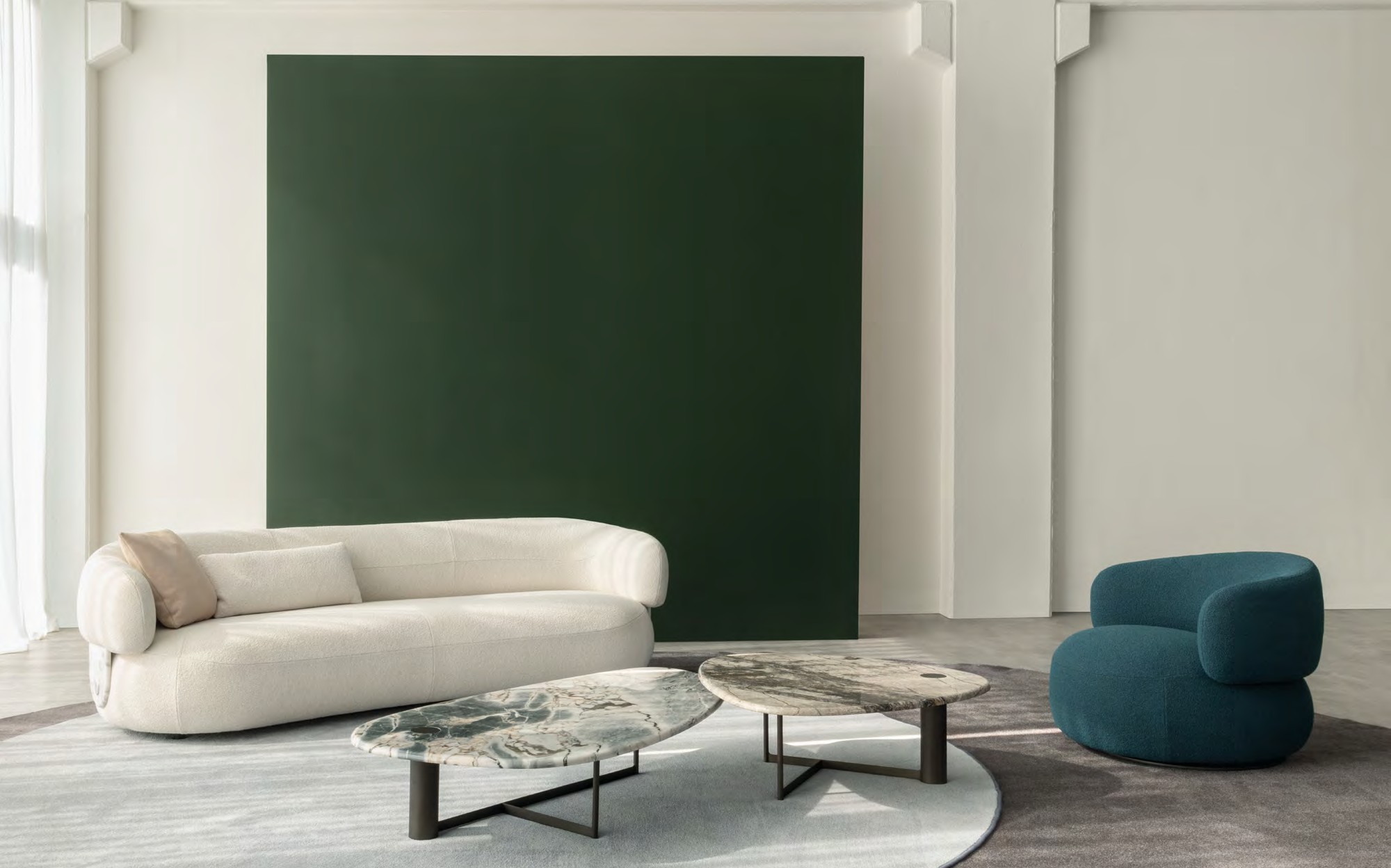 Lenzi Home Collection 2024 curved boucle sofa with marble coffee tables and blue armchair Lenzi Home Collection 2024 curved boucle sofa with marble coffee tables and blue armchair – Italian luxury furniture