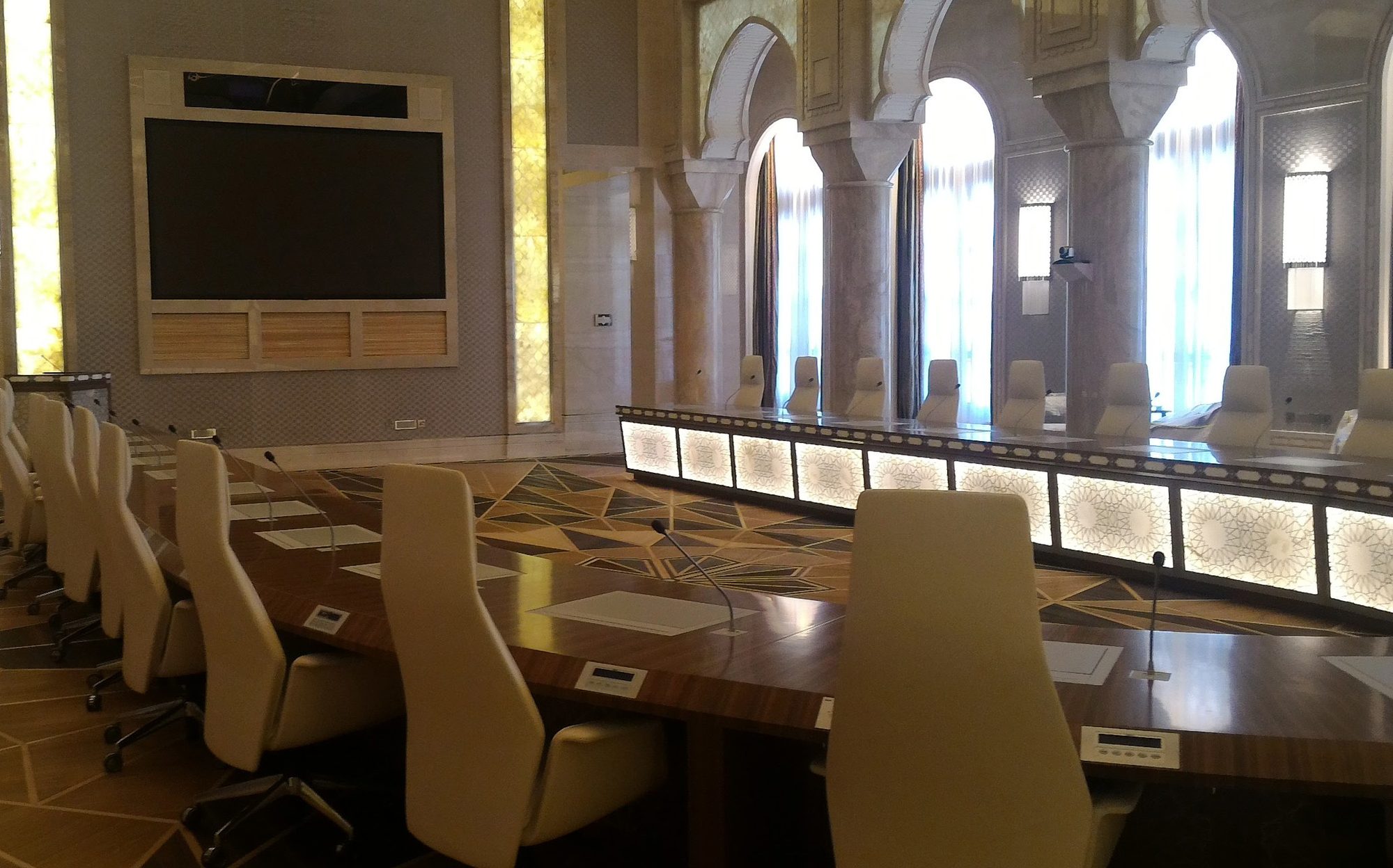 Conference table with upholstered chairs and wall screen, Presidential Palace Abu Dhabi | 101domus