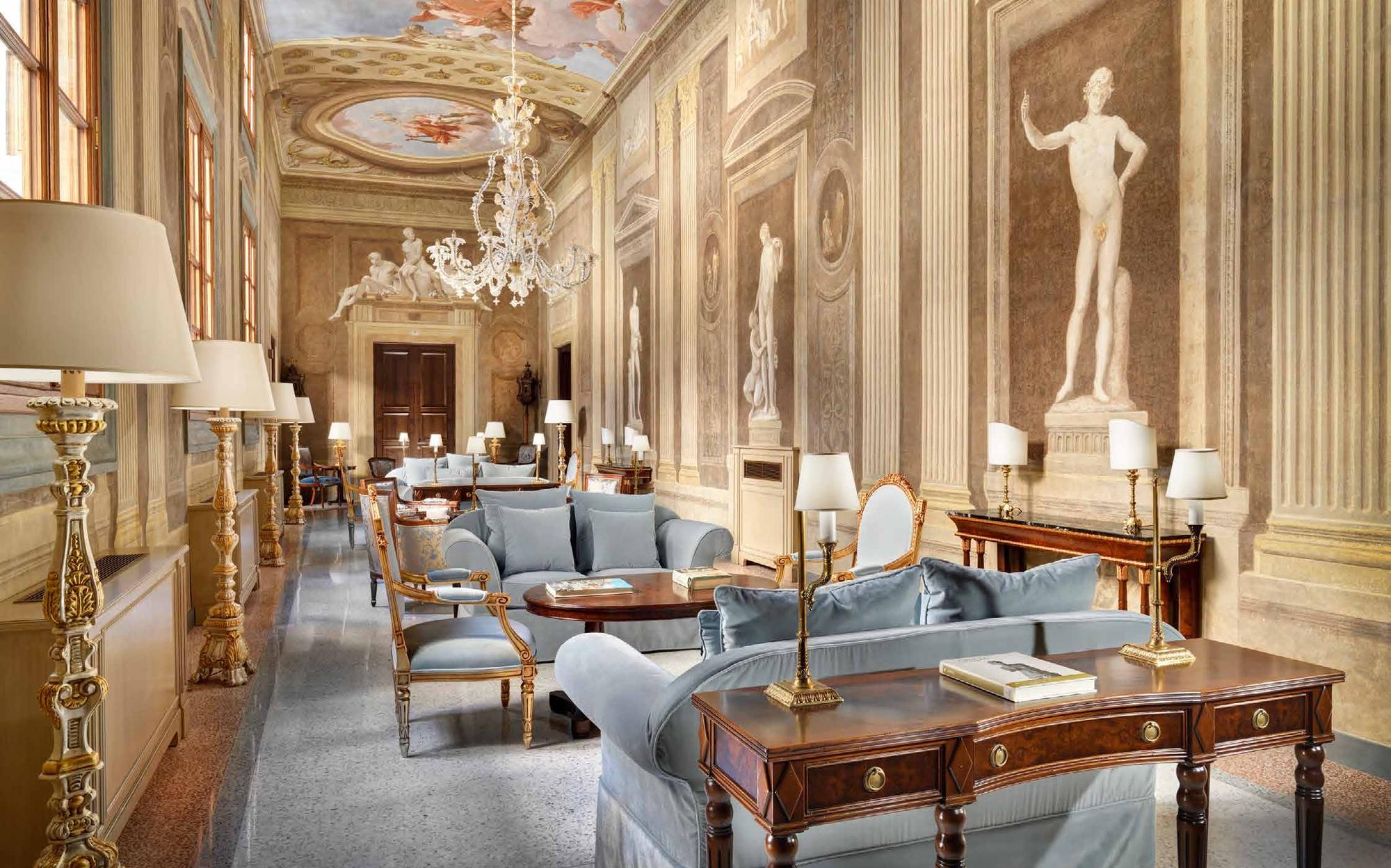 Frescoed gallery salon with classical statue, sofas and writing desk, Palazzo Portinari Salviati Florence | 101domus