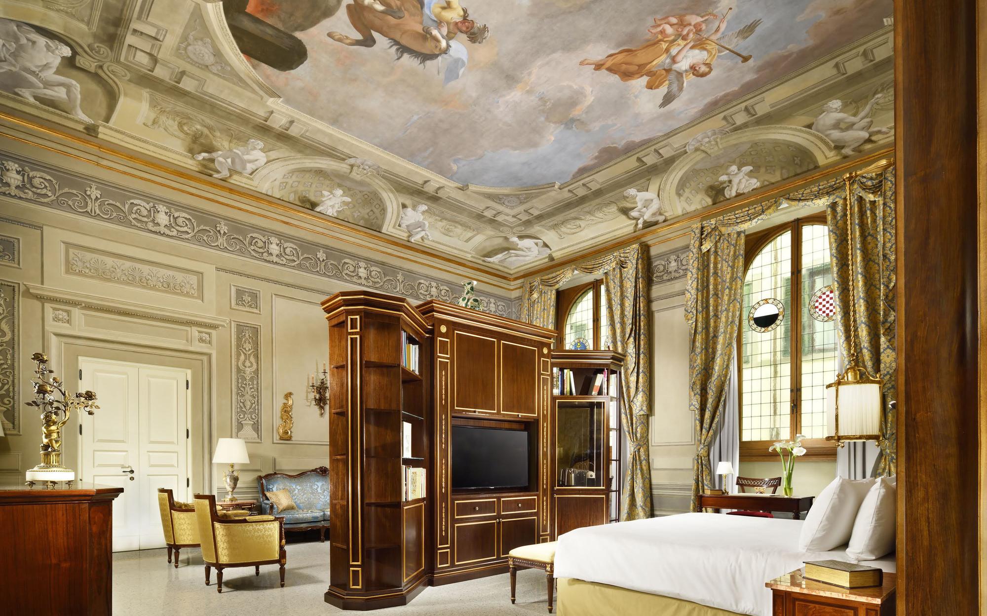 Suite under an 18th-century fresco with bed and wooden bookcase, Palazzo Portinari Salviati by Francesco Molon | 101domus