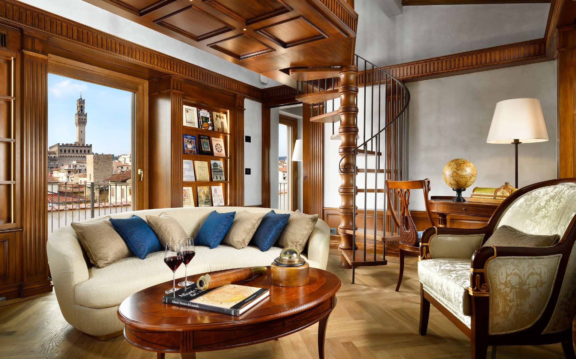 Living room with curved sofa, spiral staircase and Palazzo Vecchio view, Francesco Molon project Florence | 101domus