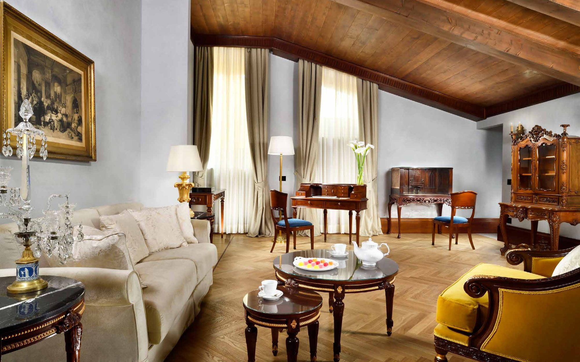 Suite living room under wooden beams with sofa and secretaire, Palazzo Portinari Salviati Florence | 101domus