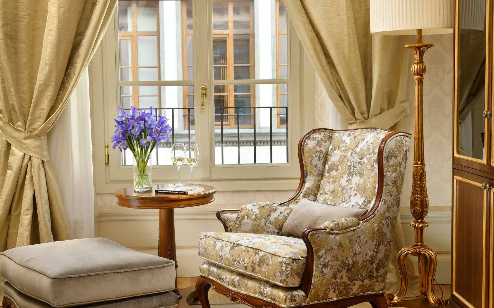 Upholstered armchair with ottoman and pedestal table by the window, Palazzo Portinari Salviati suite | 101domus